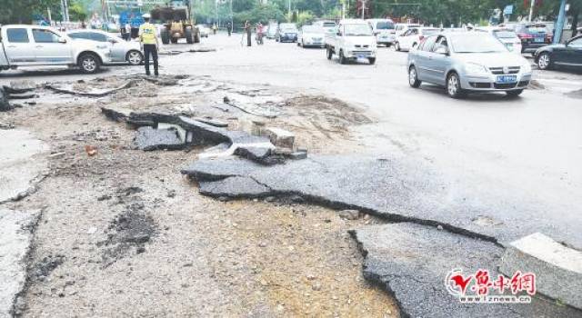 博山沿河西路与中心路路口,路面的沥青层被雨水冲了下来.