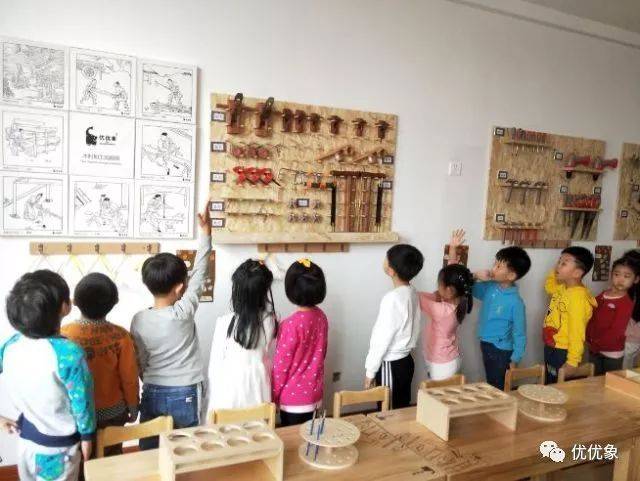 孩子们走进了幼儿园里的"木工坊",穿上围裙,戴上套袖,戴上护目镜和