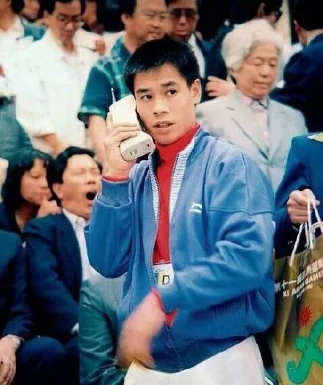 来自李宁 90 年代手拿大哥大,身穿亚运会领奖服(创始夹克)的照片