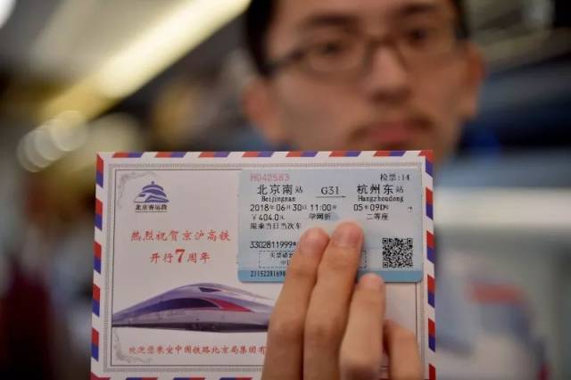 乘务员为当日乘坐g31次列车的旅客赠送纪念明信片和纪念徽章