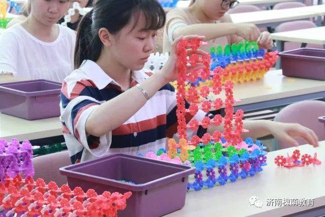 这边教师们用雪花片巧妙地搭建出"巨型摩天轮,旋转木马,翻越过山车"等