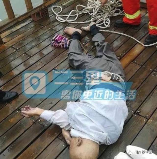 被打捞上岸的尸体,是一具光头男尸,年龄不详,在河边护栏上悬挂一灰色