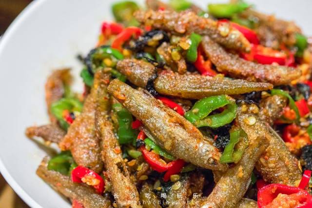将小鱼仔和青,红椒一起翻炒,酱汁慢慢渗入鱼肉里,待小鱼仔炒至金黄时