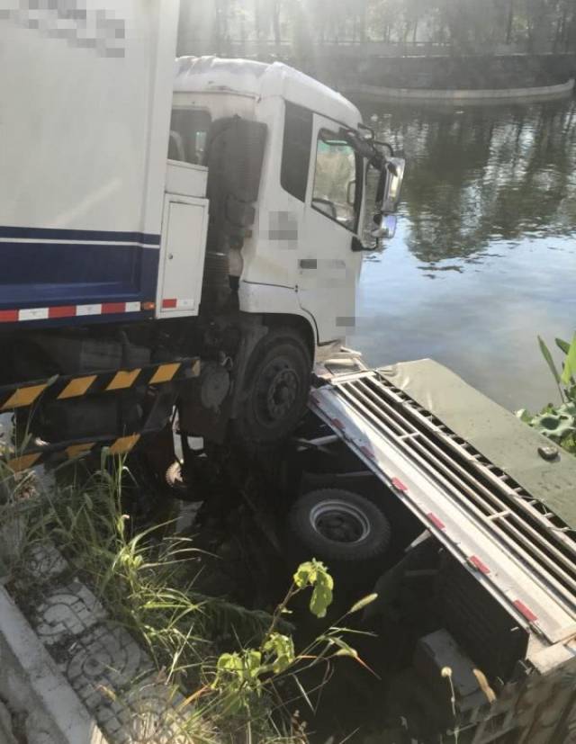 垃圾车将两辆小车撞下河 现场凌乱不堪