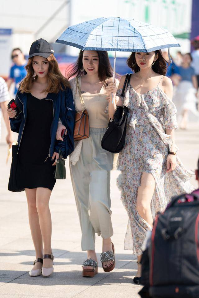 街拍:夏日街头的美女皮肤白皙,一件吊带裙时尚中透露出一丝性感