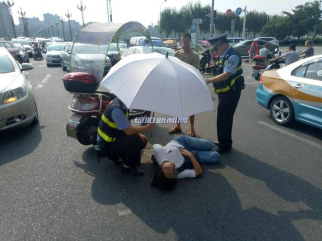绵阳女子车祸受伤倒地 民警为她撑伞等待救护
