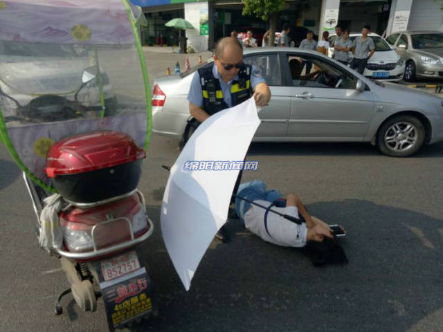 绵阳女子车祸受伤倒地 民警为她撑伞等待救护