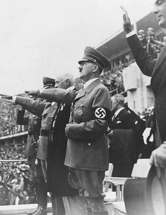 希特勒站在开幕仪式台上向下面的德国民众们行纳粹军礼