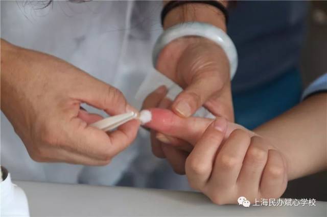 大胡老师为剥玉米时手伤的同学包扎