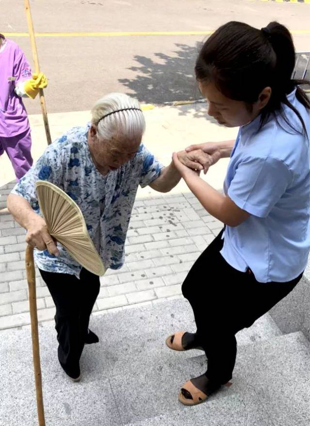 热心搀扶行动不便的老年人