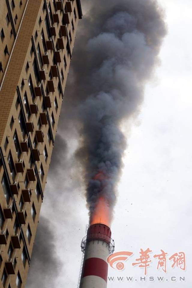 大烟囱与旁边的蓝色疑似罐体起火冒黑烟,而约150米高的空中能看到飘着