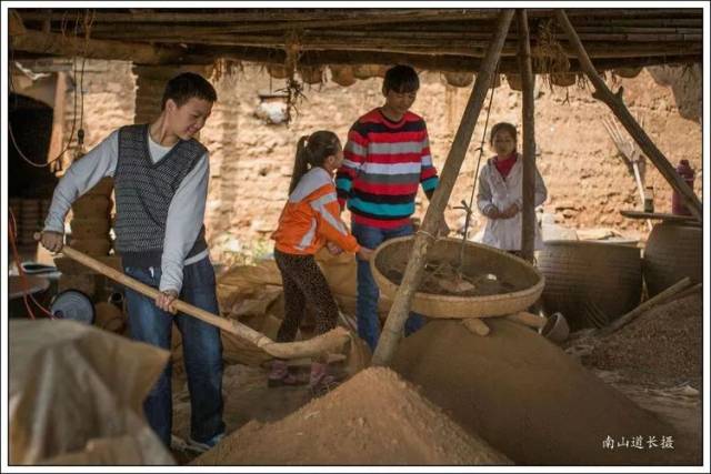 图为暑假期间窑工家的留守学生到棚子帮助泥土筛分.