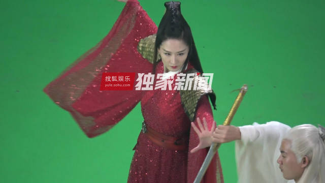 只见张雯身穿白色中衣,外面搭配布满亮片的红色古装,肩头顶着两个金色