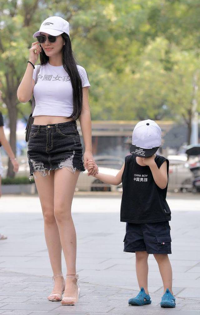 街拍:辣妈穿露脐装配短裙,秀出大长腿,变得更有魅力