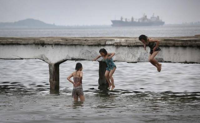 朝鲜抓拍,很多人在河里洗澡,还有女孩跳水