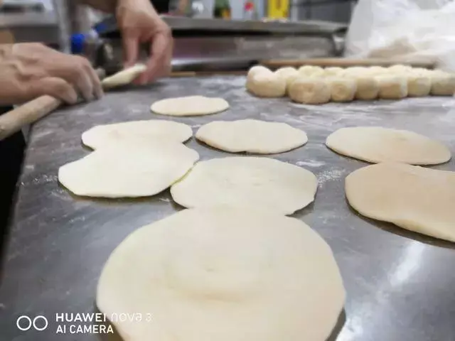 16.将包子面皮擀成中间厚边缘薄的形状.