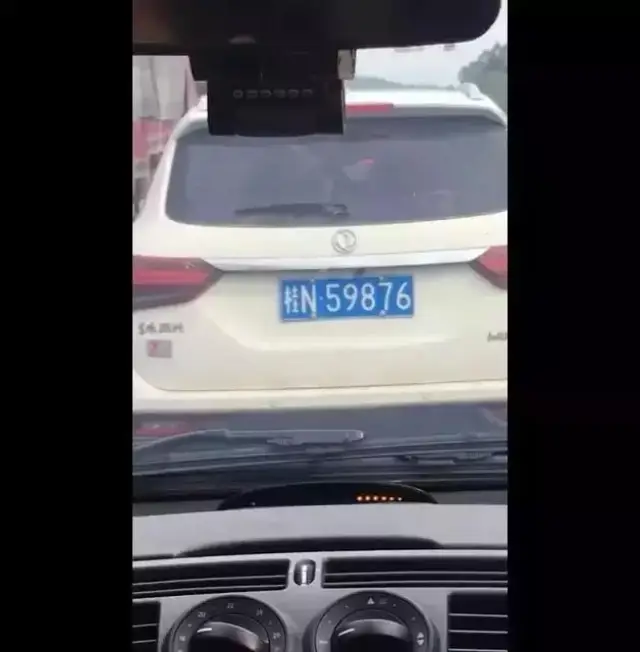 一辆车牌号为桂n59876白色汽车,占用了应急车道.