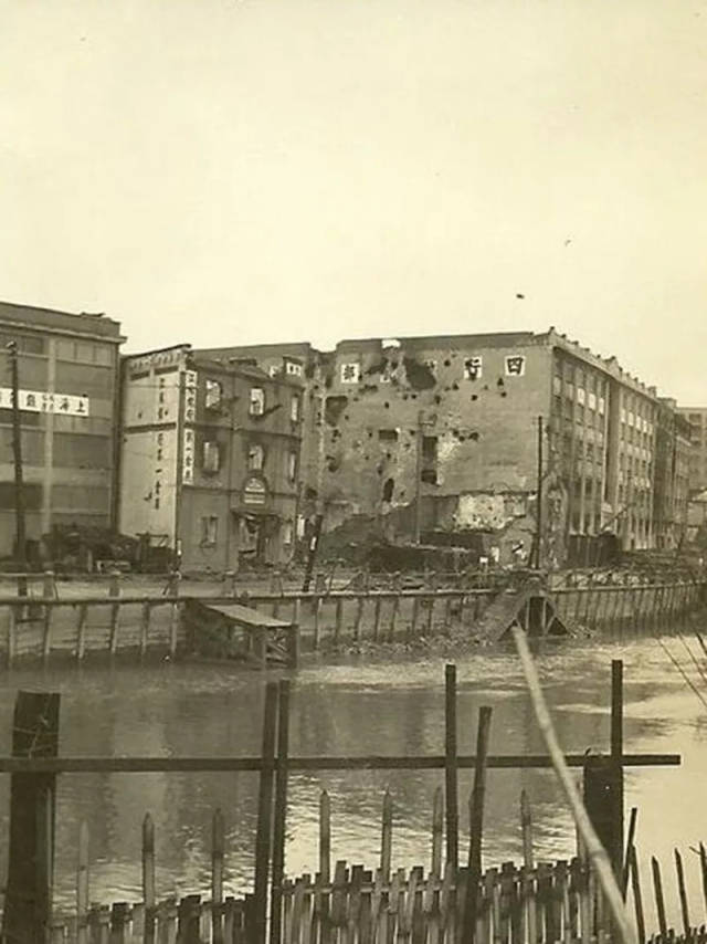 1937年底,从苏州河南岸拍摄的四行仓库,千疮百孔