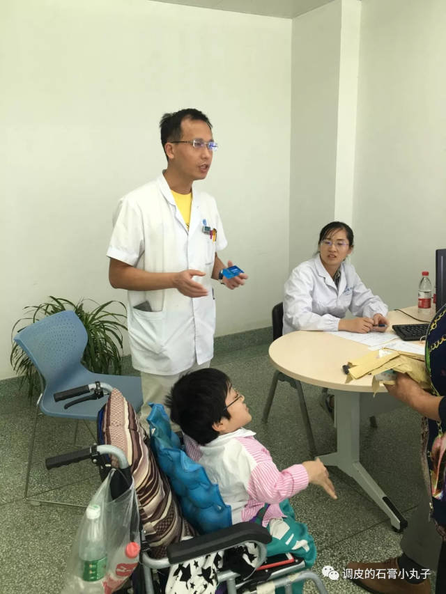 唐欣医生检查患儿,并告诉家长注意定期复查及其他注意事项.