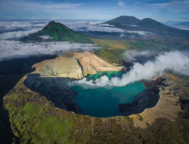 中国内蒙古某火山,该火山青草丛生,行人沿火山口边缘缓行.