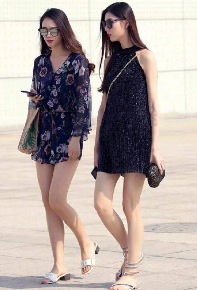 两个正在街头行走的性感气质美女,白皙笔直的大长腿格外引人注目,长发