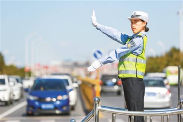 图为国庆期间,河北省武安市交通警察大队城区一中队民警在指挥交通.