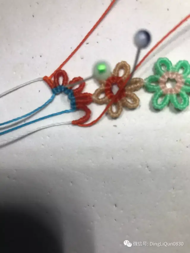 第三个花瓣我们只要编半个花瓣,前面斜卷结的部分是一样的,蓝色橙色