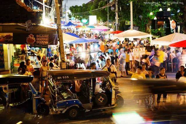 周末夜市的流光溢彩和来来往往的人流,让整个街道都充满了烟火气.