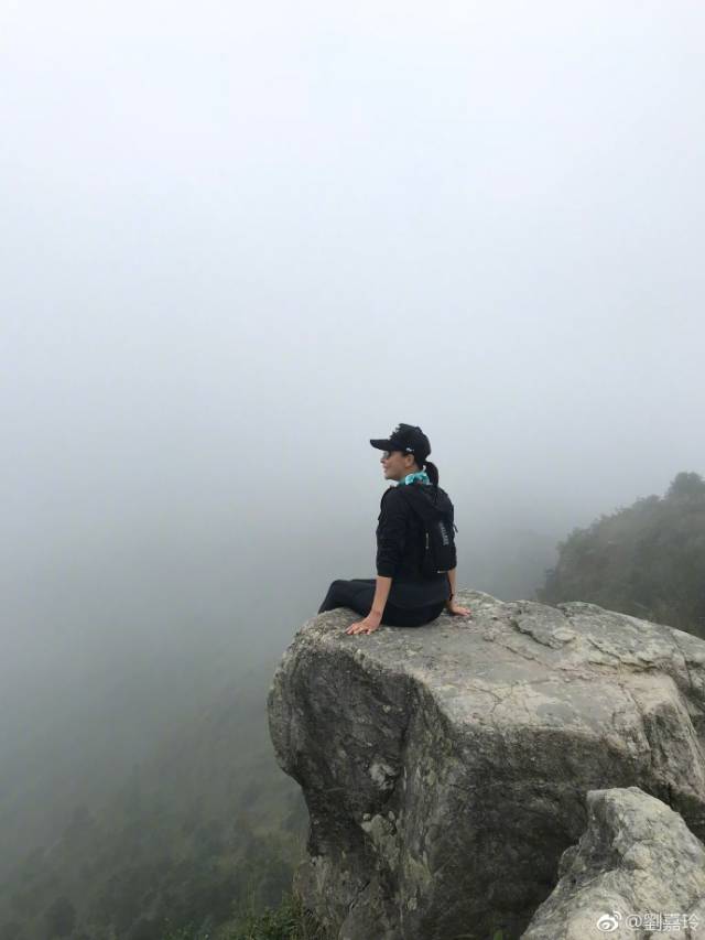 在雾蒙蒙的环境中,刘嘉玲只身坐在一处悬崖边缘,脚下悬空,像是万丈
