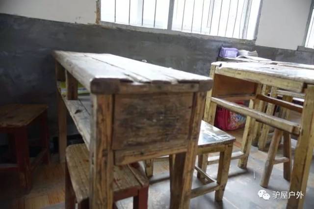 多年重复使用的简易木课桌,因多次检修,桌椅上有很多钉子,经常有学生