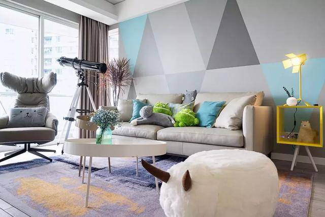 沙发背景墙采用拼接撞色的三角形色块,使用的是更环保的硅质漆,地板是