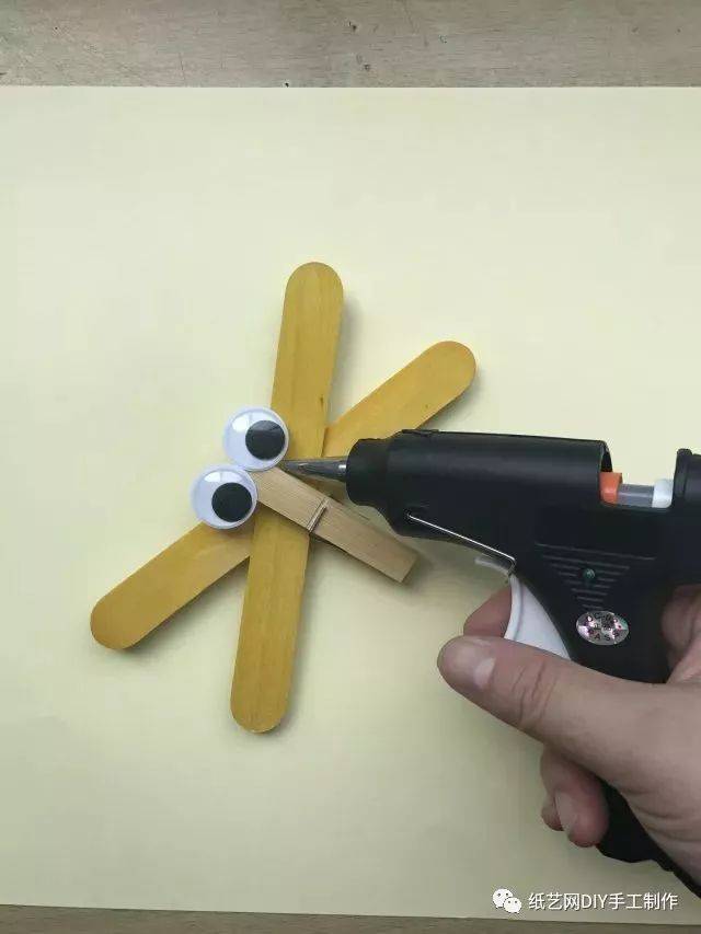 用热熔枪把活动眼珠装在竹木夹子的一端.