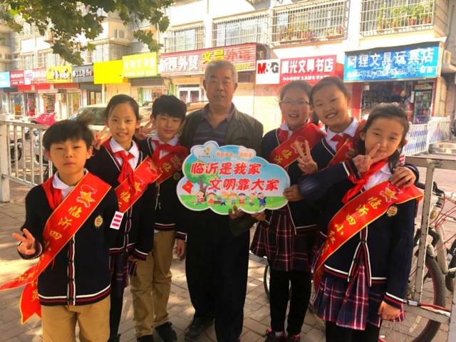 大队长赵金子带领大队委员向路人宣讲创城的知识,号召大家都一起投身