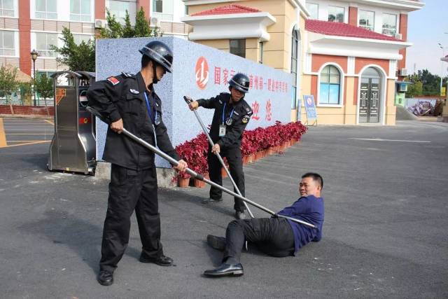 盾牌等工具及时阻止"歹徒"进入校园,同时,学校反恐防暴队员迅速赶来