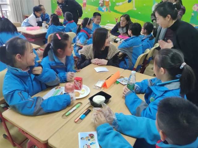 在小组合作中,upton infant学校老师和学生们进行愉快交流.
