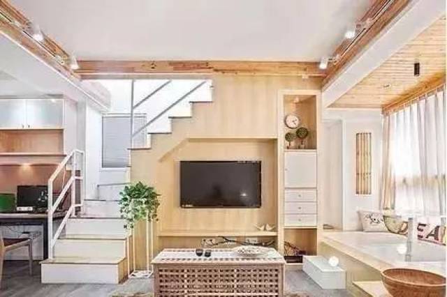 如果楼梯刚好在客厅,可以把楼梯下方墙面设计成电视背景墙,在增加储