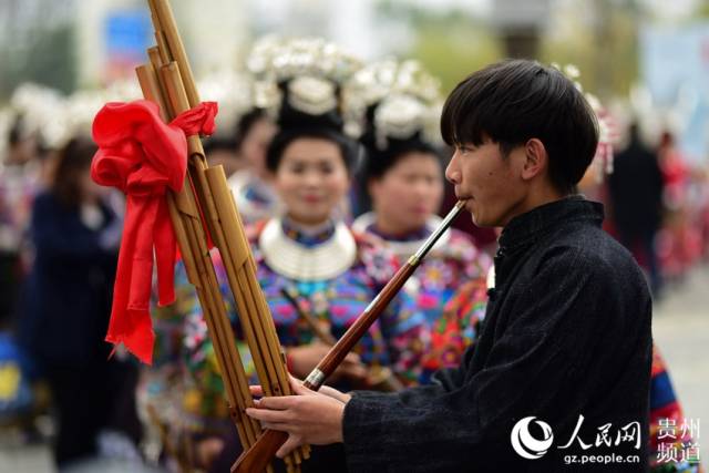 12月1日,在贵州省丹寨县万达小镇,一名苗族芦笙手在吹奏芦笙.