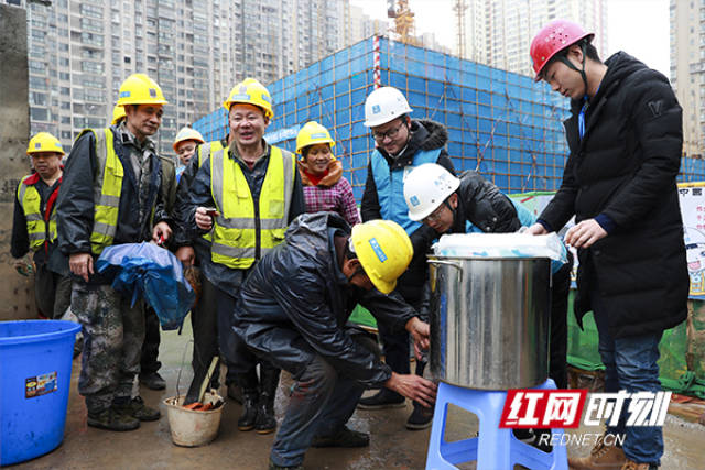 建筑工人下班后纷纷从志愿者手中接过姜汤.