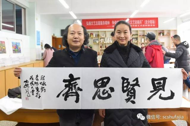 书法家赵安如现场书写作品 校长段晓莉(右)代表学校接受作品