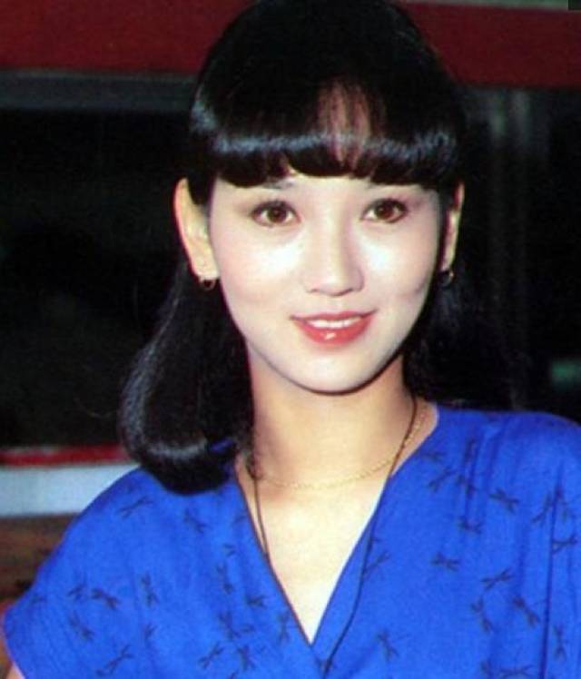 穿着蓝色衣服的赵雅芝长相清丽,齐刘海让她更显甜美,乌黑的秀发让她的