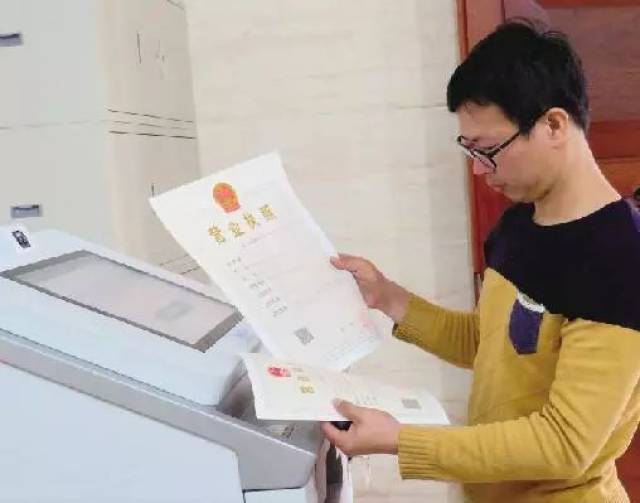 龙海市榜山镇个体户经营者郑玉贤先生高兴地从自助打照机取出自己的