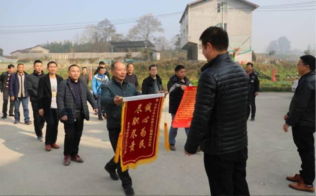 12月17日,十余名枧坝工区的农民工将一面"诚心为民,尽职尽责"的锦旗和