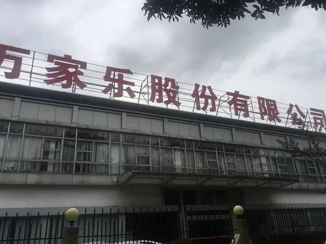 仍竖立着"广东万家乐股份有限公司"字样,二楼窗户透出稀疏破败的窗帘