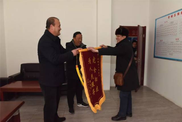 副区长齐成喜,西关办事处书记王逢伟从老郭手中接过锦旗