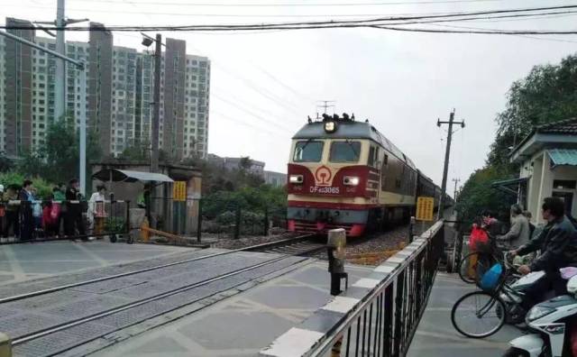板桥宁芜铁路203道口前,两道铁栏杆将火车轨道和行人车辆隔开.