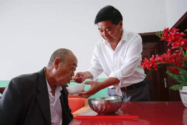 李银江给残疾"爸爸"朱银业喂饭(周海军拍摄)