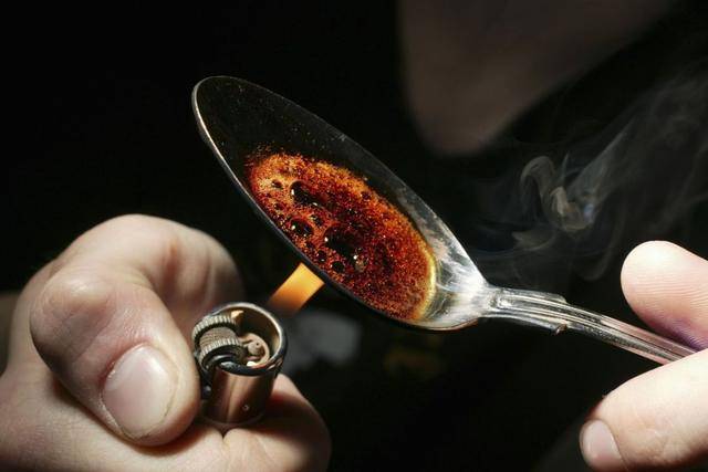 吸毒者把海洛因研成粉末状,然后将粉状海洛因放在勺子或其他工具上.