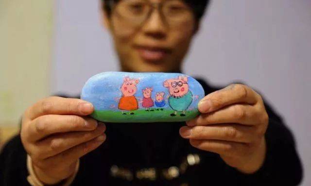1月22日,甘肃张掖,市民展示在石头上绘制的小猪佩奇一家.