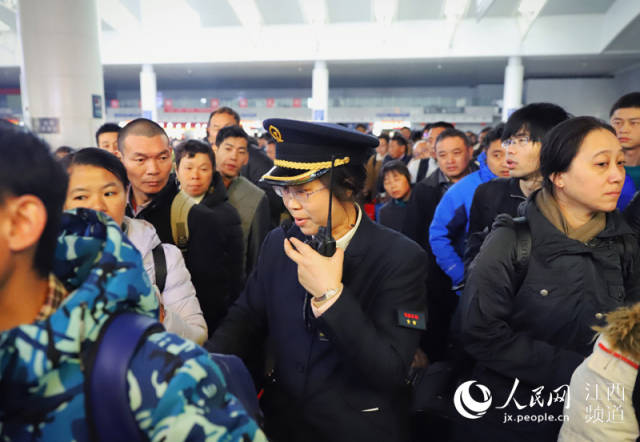 南昌火车站检票口工作人员在核对车票,引导旅客有序进站.