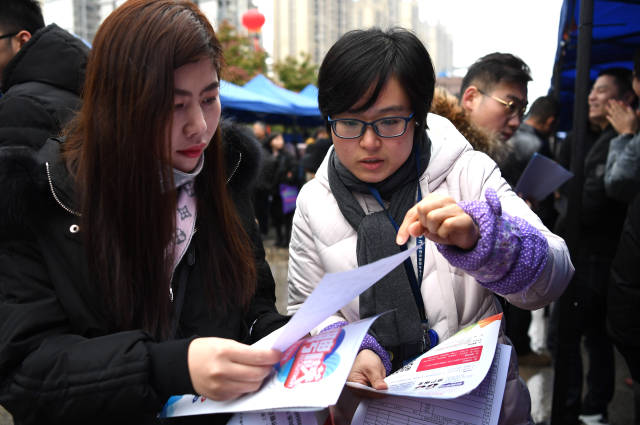 2月14日,求职者在招聘会现场与用人单位洽谈.